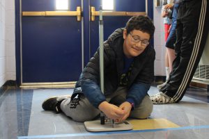 Student prepares to launch a straw rocket in middle school engineering class