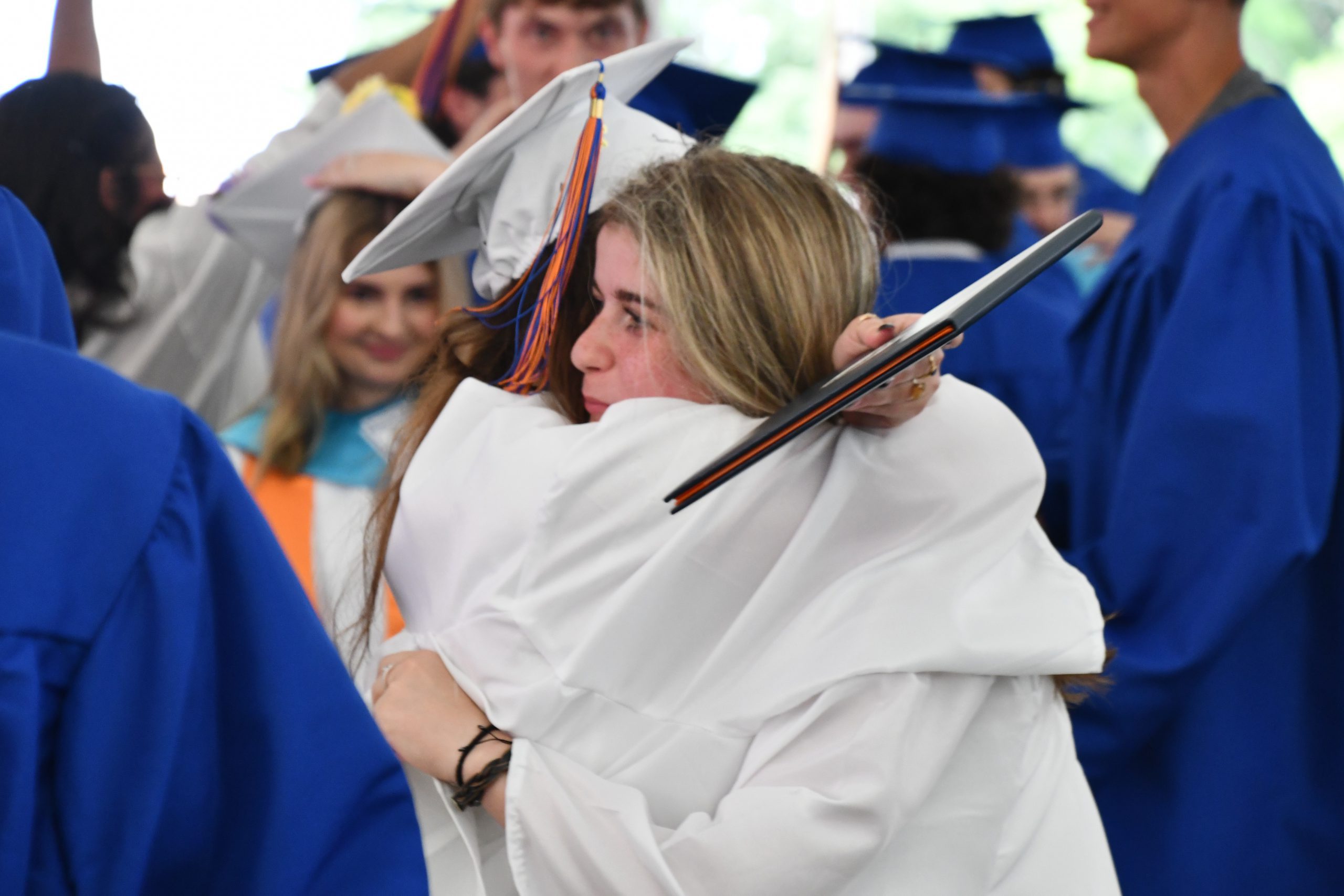 students hug after graduation