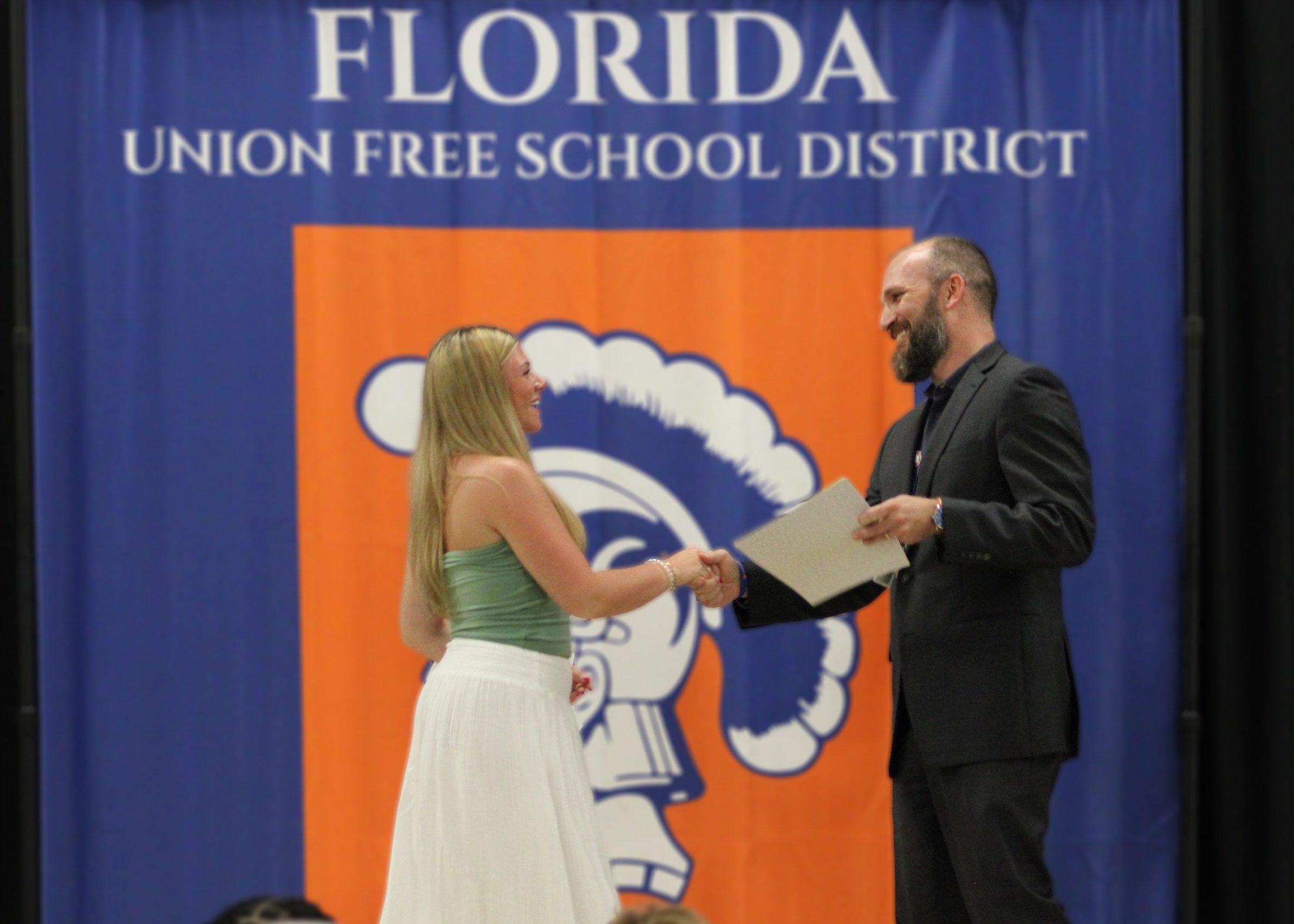 student shakes Principal Maesano's hand while recieveing award