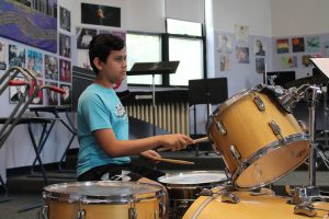 student plays the drums at summer band