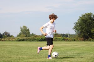 student dribbles soccer ball at tryouts