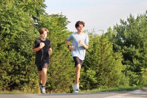 Two cross country runners come up the hill at Golden Hill