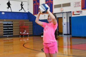 student smiles while setting the ball