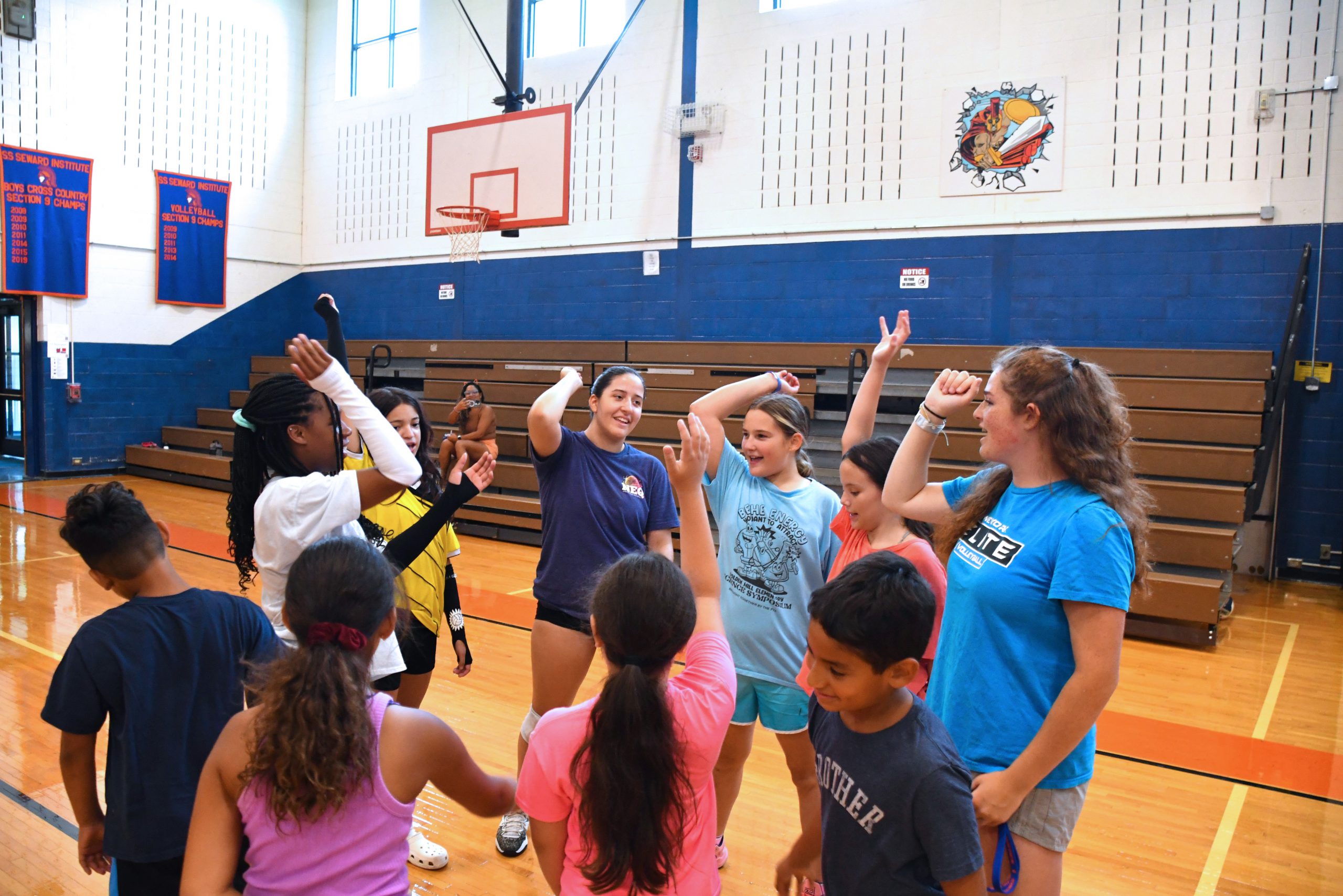 athletes come together for a final cheer at the end of the clinic