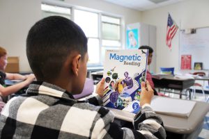 student looks at magnetic reading book