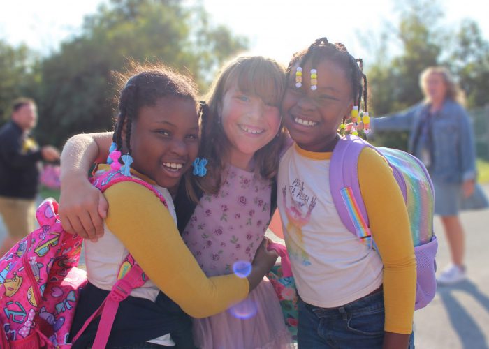 students smile outside on the first day of school