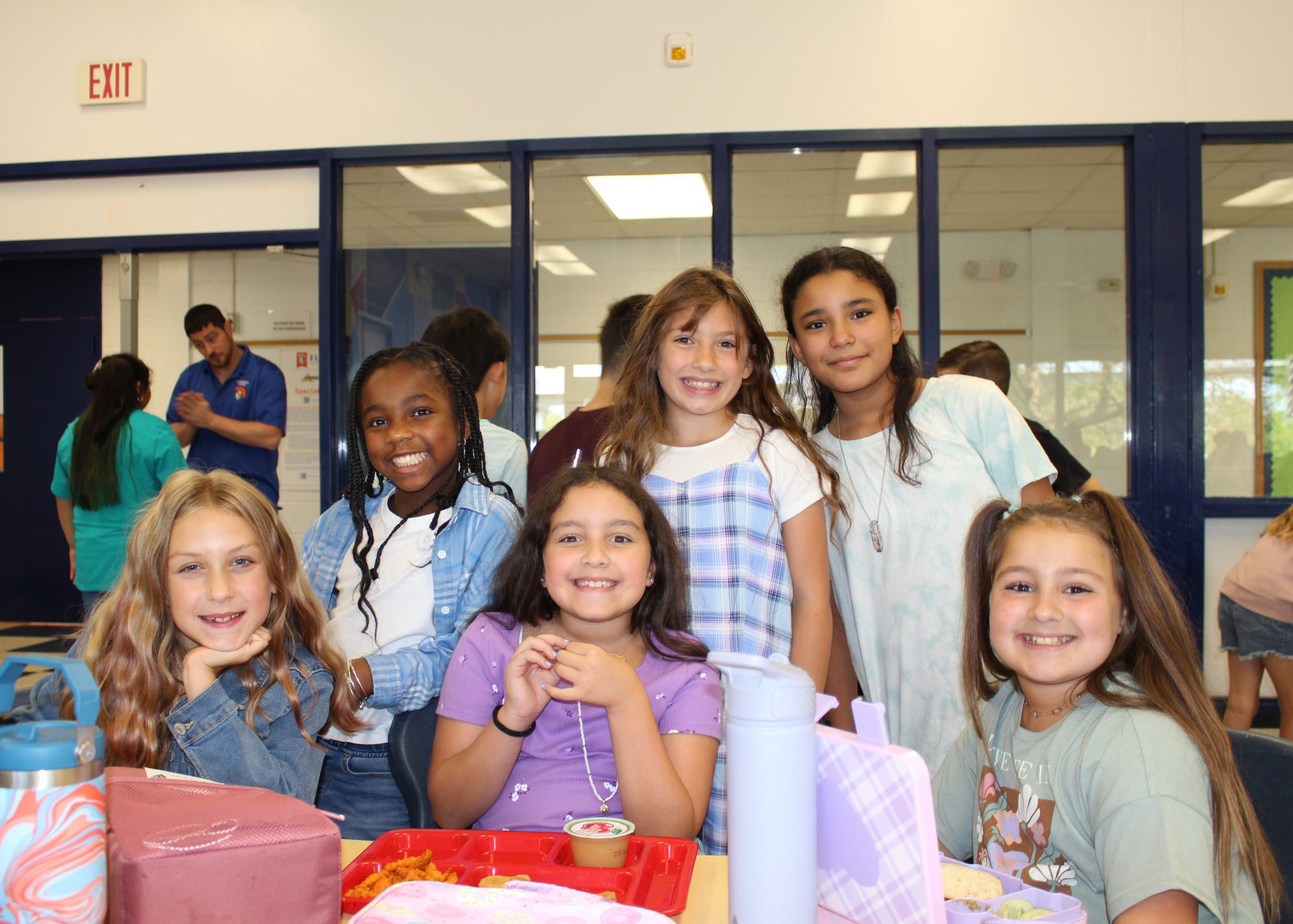 a group of students smile together during lunch