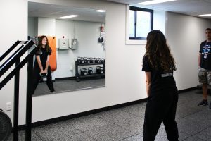 student uses mirror to adjust her form