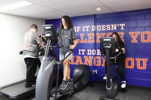 three students use cardio equiptment