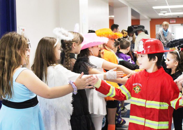 students high five others as they exit the costume parade