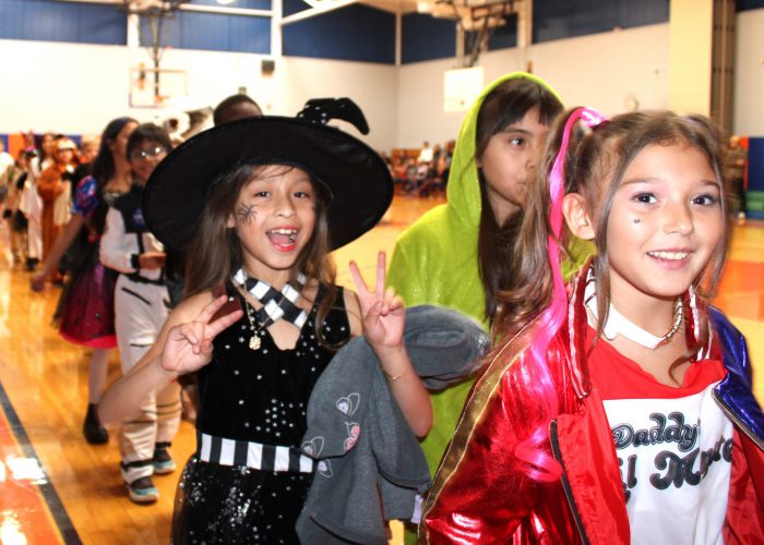 students smile as they exit the costume parade