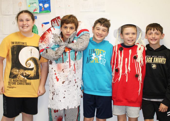 students dressed for costume party smile at the camera