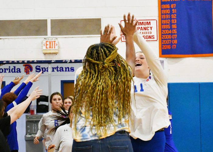 Abby Orlando high fives coach upon entering the volleyball court