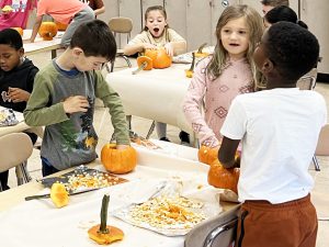 students work on pumpkins in classroom