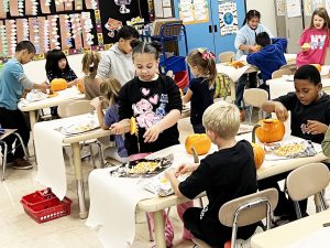 students work on pumpkins in classroom