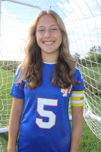 Taylor Vogt smiles near the soccer goal in her uniform