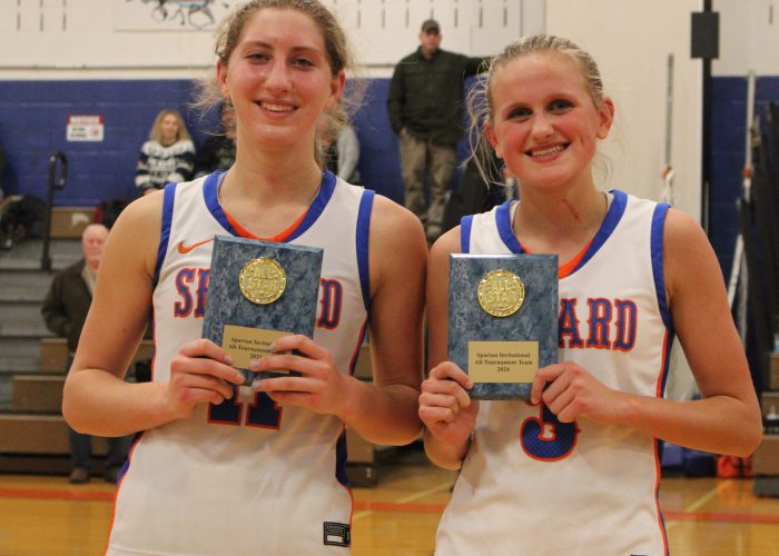 Two girls basketball players pose with plaques from the Spartan Invitational for making the All-Tournament team