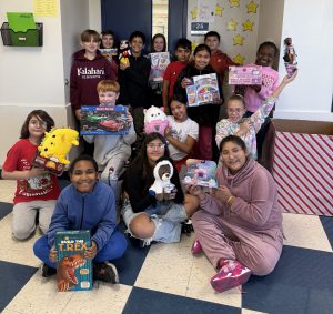 5th grade class pose for picture with toys they collected