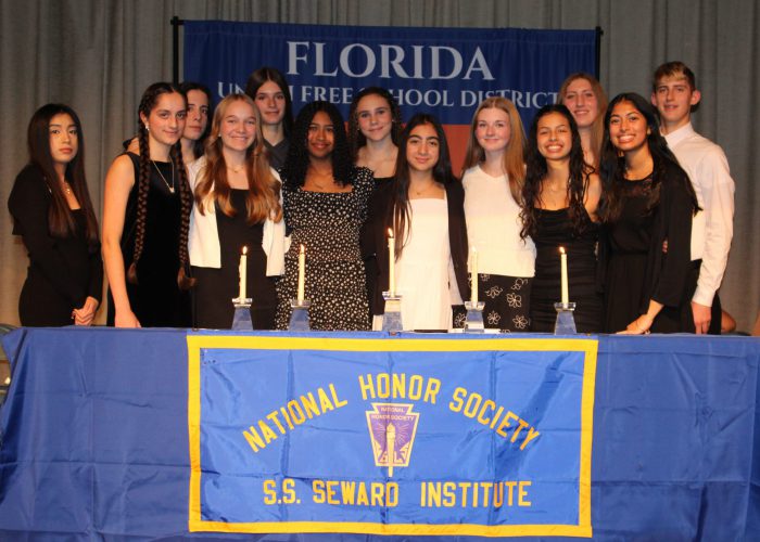 Students pose on stage for NHS induction