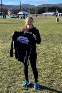 Student holding state championship shirt for cross country