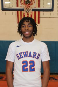 Student athlete poses in white uniform 