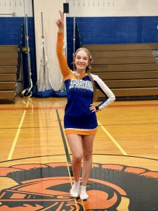 Student athlete poses in blue cheer uniform