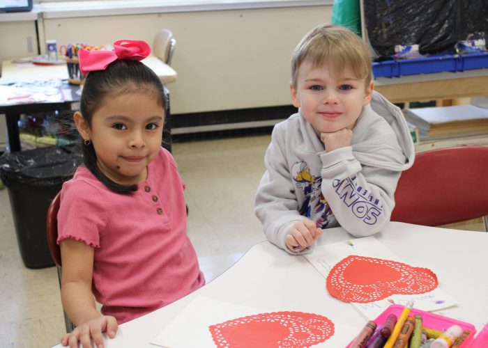 Students pose while working on valentines day project