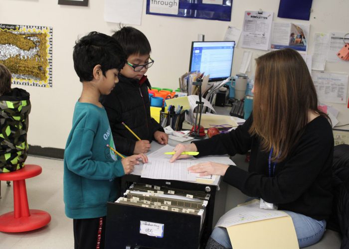 Teacher reviewing work with students