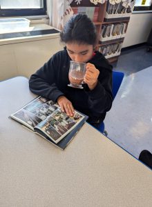 Student drinks coco and reads a book